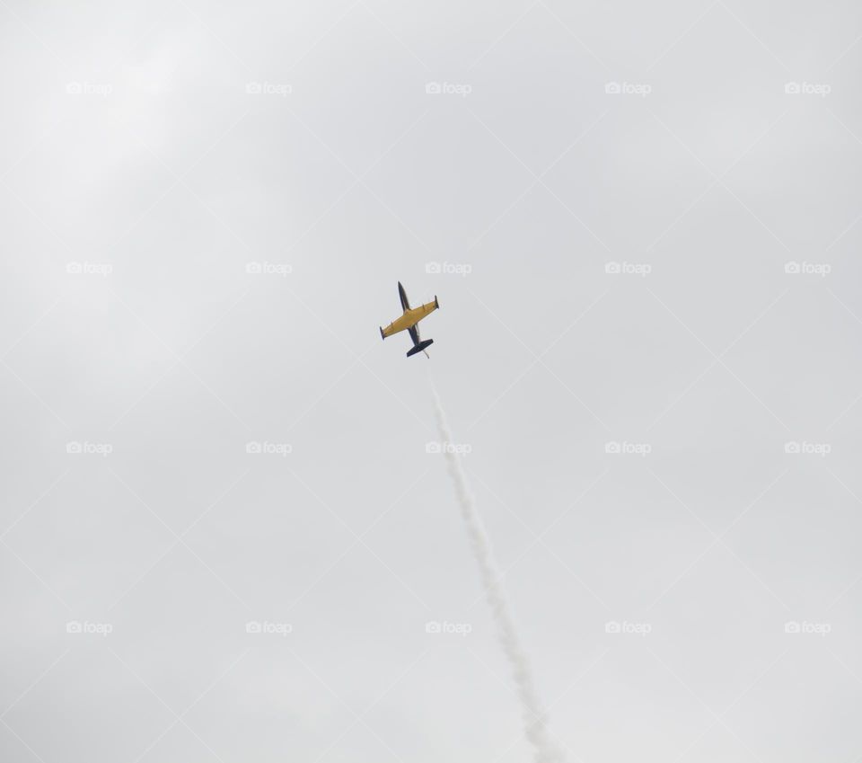 The plane is flying against the blue sky. Aerobatic figure, military aircraft.