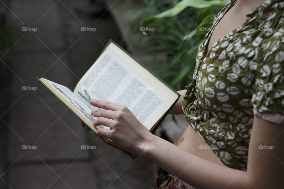 Girl hold a book in garden