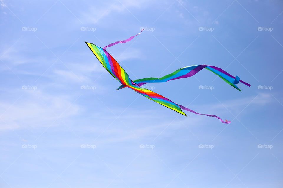 Kite in rainbow colors flying in the sky 