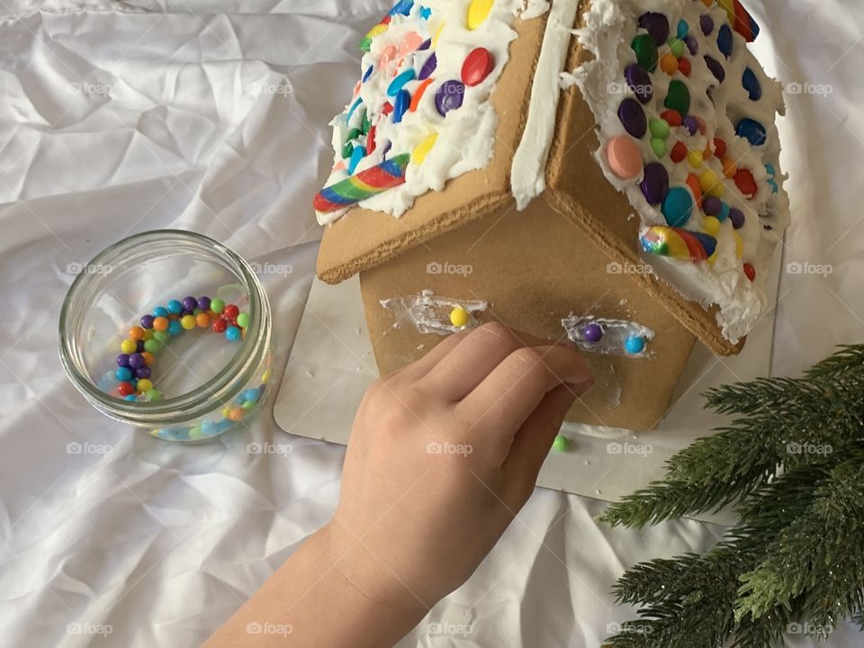 Little boy Decorating a ginger house for the holidays 
