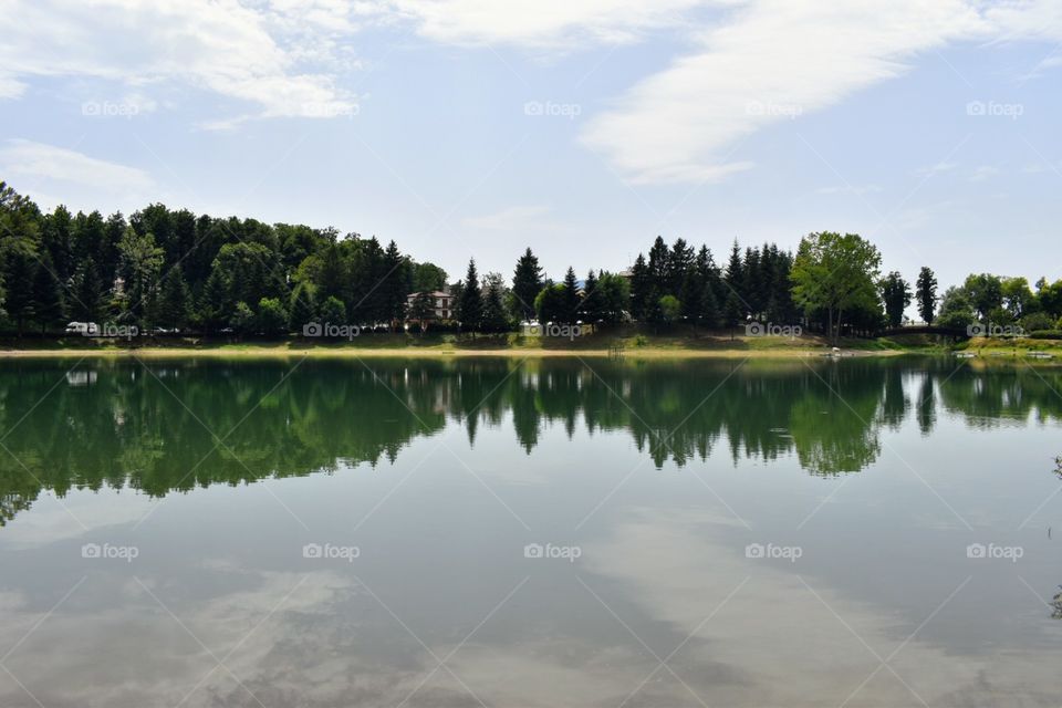 reflection of trees and sky in water lake