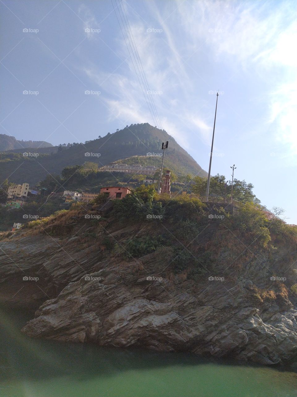 Beautiful view of the rocky hill on the bank of holy Alaknanda with mountains on the backdrop