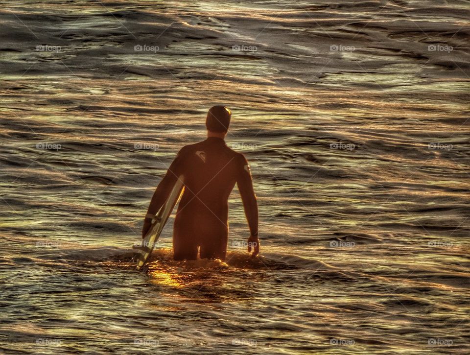 California Surfer Heading Into The Waves. Surfing At Sunset