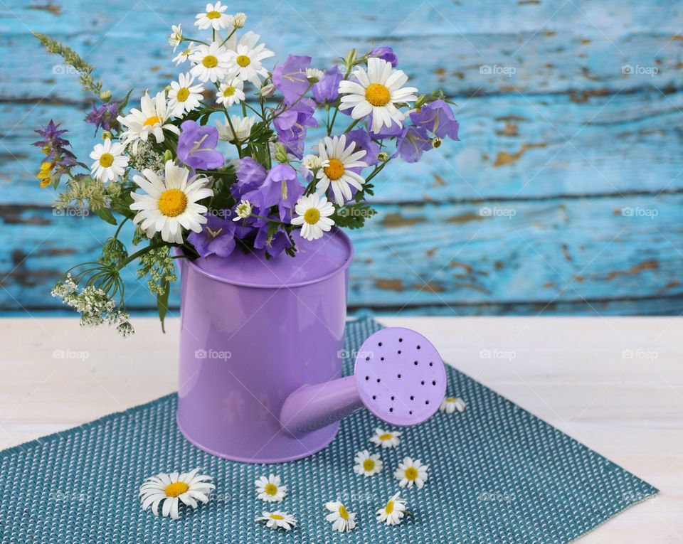 summer wild flowers in a purple watering can
