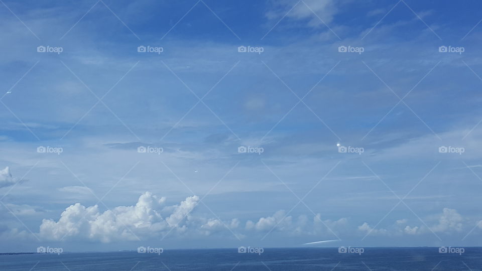 Clouds stretch out over a bright blue sky.