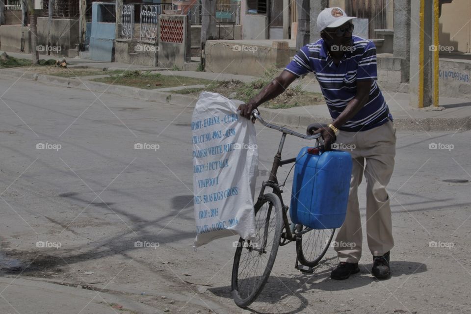 People In Cuba.Man Transporting On Bike