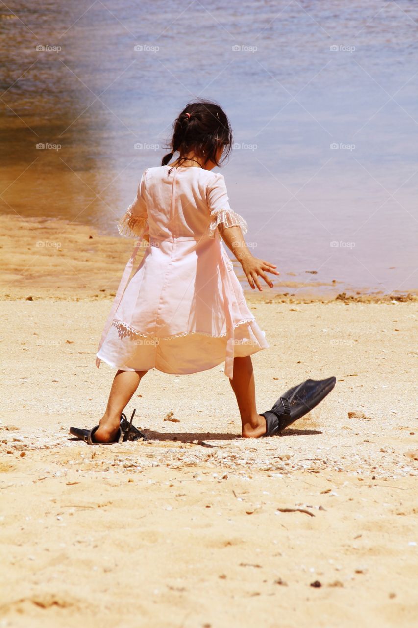 Little girl dancing at the beautiful Ene' io Beach.