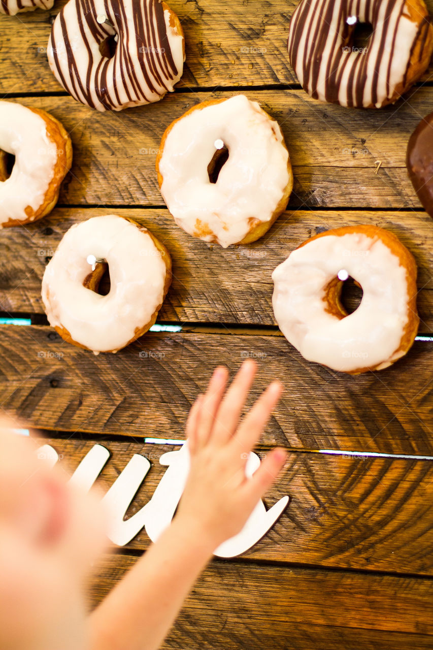 Love this moment of joy and anticipation  when my girl reached for a donut at a carnival. Image of donuts and hand reaching for a donut.