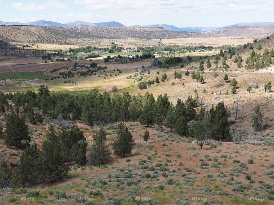 A view down hills into the farming valley and the small rural community of Gateway in Central Oregon on a sunny summer  day. 