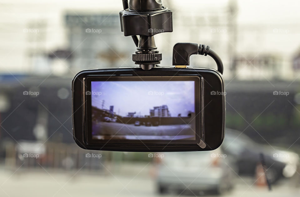 Buildings and cars photos on camera in car.