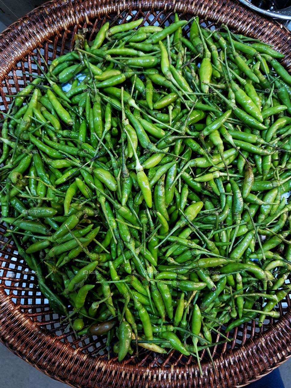 background close up of green pepper chilies at the market