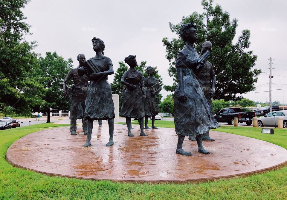 Rising up against a gray Arkansan sky, Testament: The Little Rock Nine Monument stands on the green lawn of the Arkansas State Capital to honor the  African American students that courageously integrated Central High School 61 years ago. 