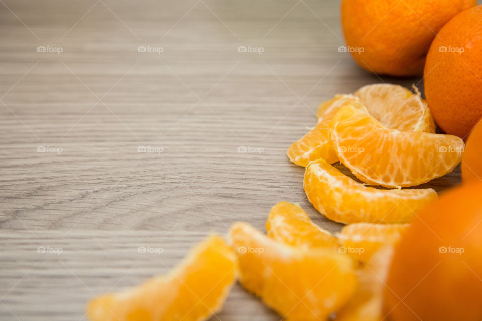 Whole and sliced citrus fruit close up on wooden board. Orange fresh fruits with empty space around.