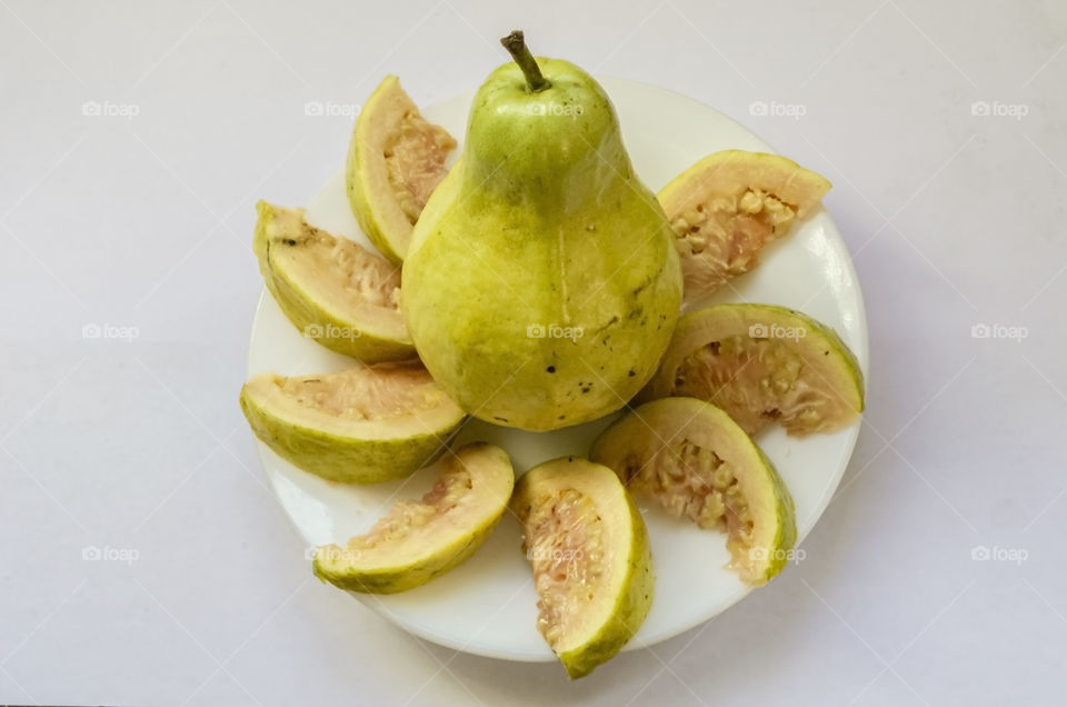 Whole And Slices Of Guajava In A Small Plate