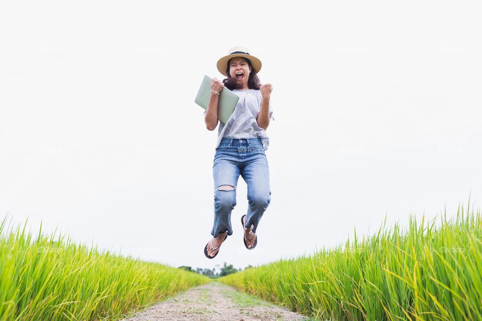Asian woman are happy and jumping in the rice fields
