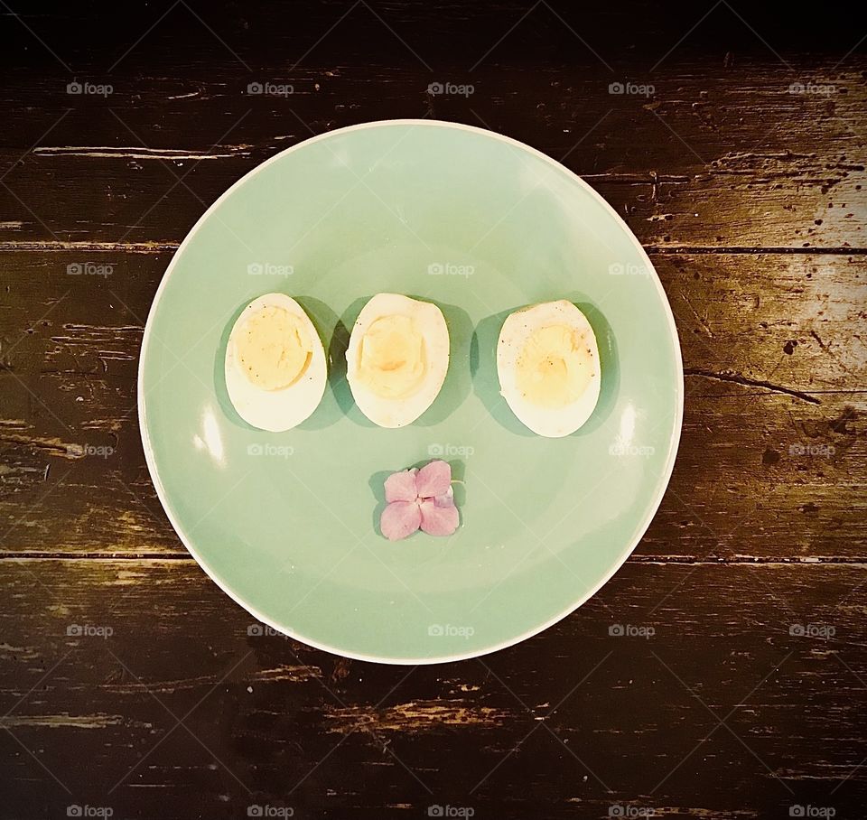 Plate of 3 hard boiled eggs and a delicate flower 