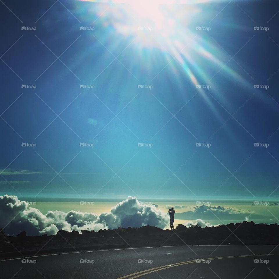 Photographer view from mountain above the clouds Hawaii silhouette sunny sun 