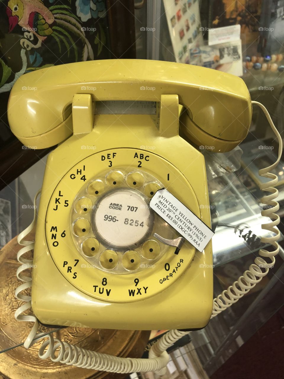 Antique yellow corded rotary telephone/phone.