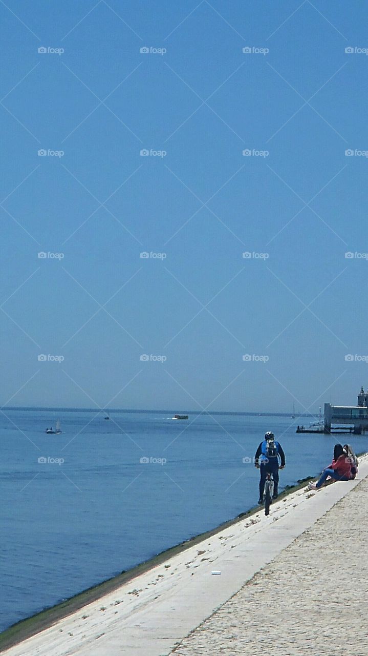 A man riding his bike along the river