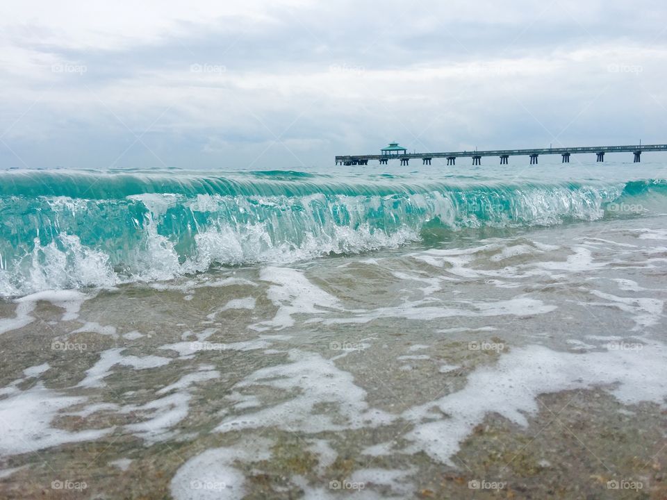 A beautiful blue wave crashing near the Deerfield Beach Pier here in Florida. 