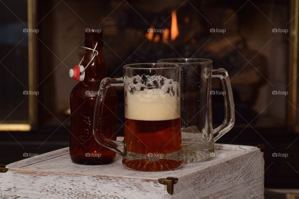 Hygge, cozy by the fireplace with a cold brew