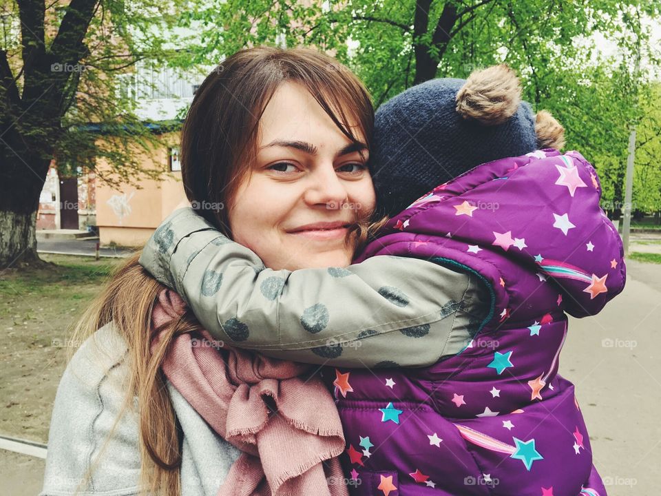 Happy mom hugging with her kid.