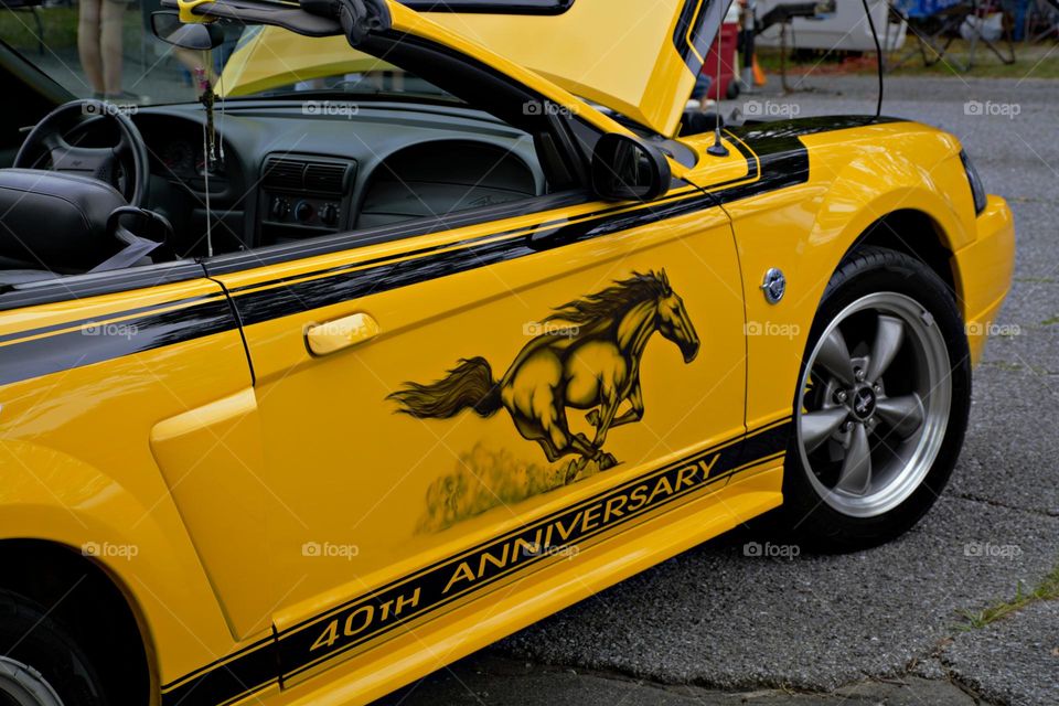 Yellow 2004 Ford Mustang pony car. This is one of the cars that features performance-oriented upgrades 