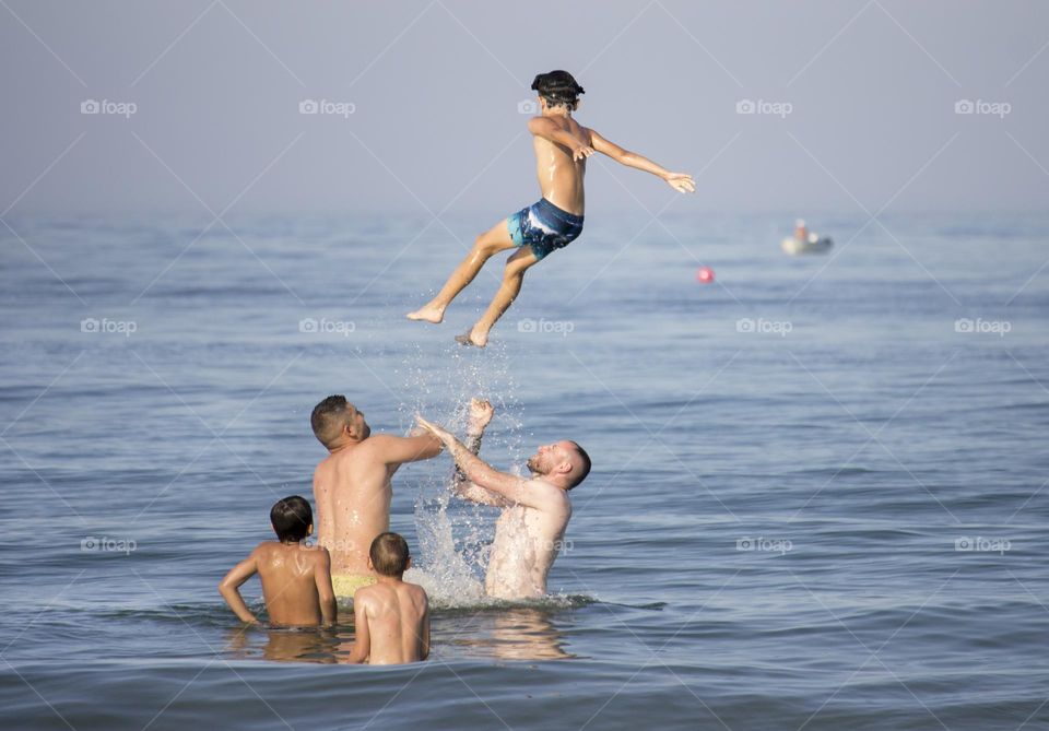 Family fun in the sea water, jumping