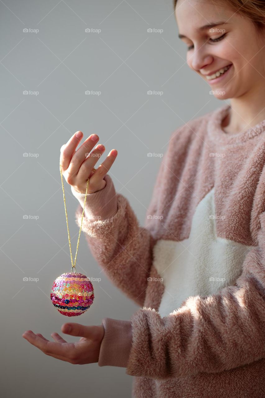 Young girl enjoying her handmade colorful Christmas ball
