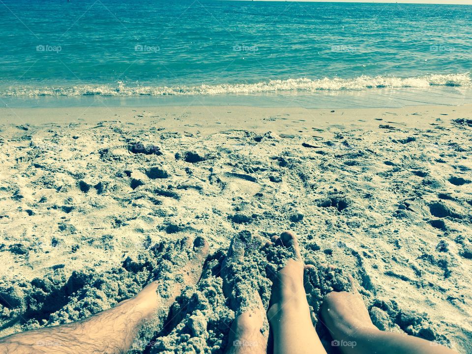 Couple's feet in the sand.