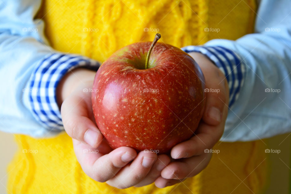 Kid holding ripe red apple