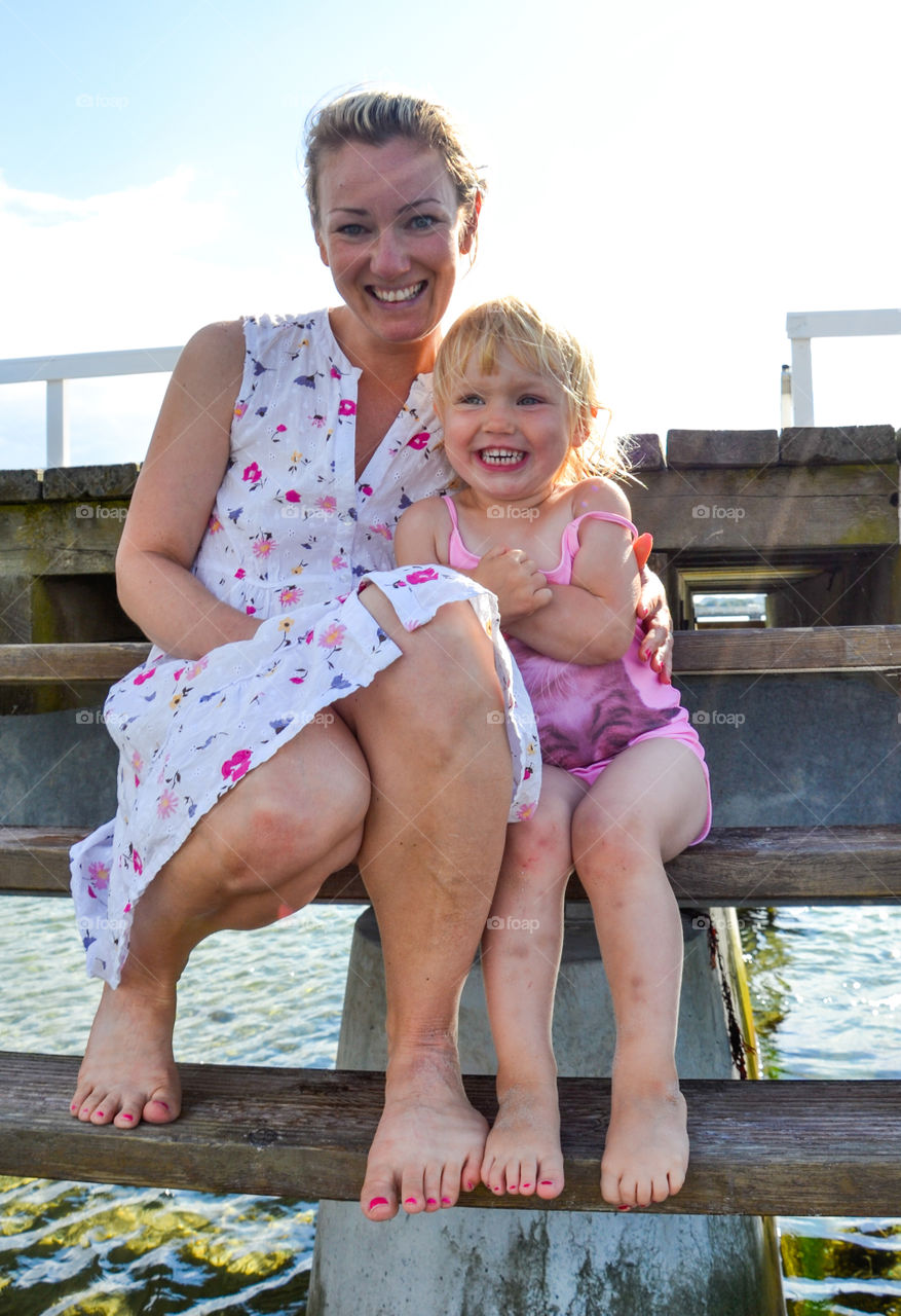 Little girl and her mother posing at the Ribban beach in Malmö Sweden.