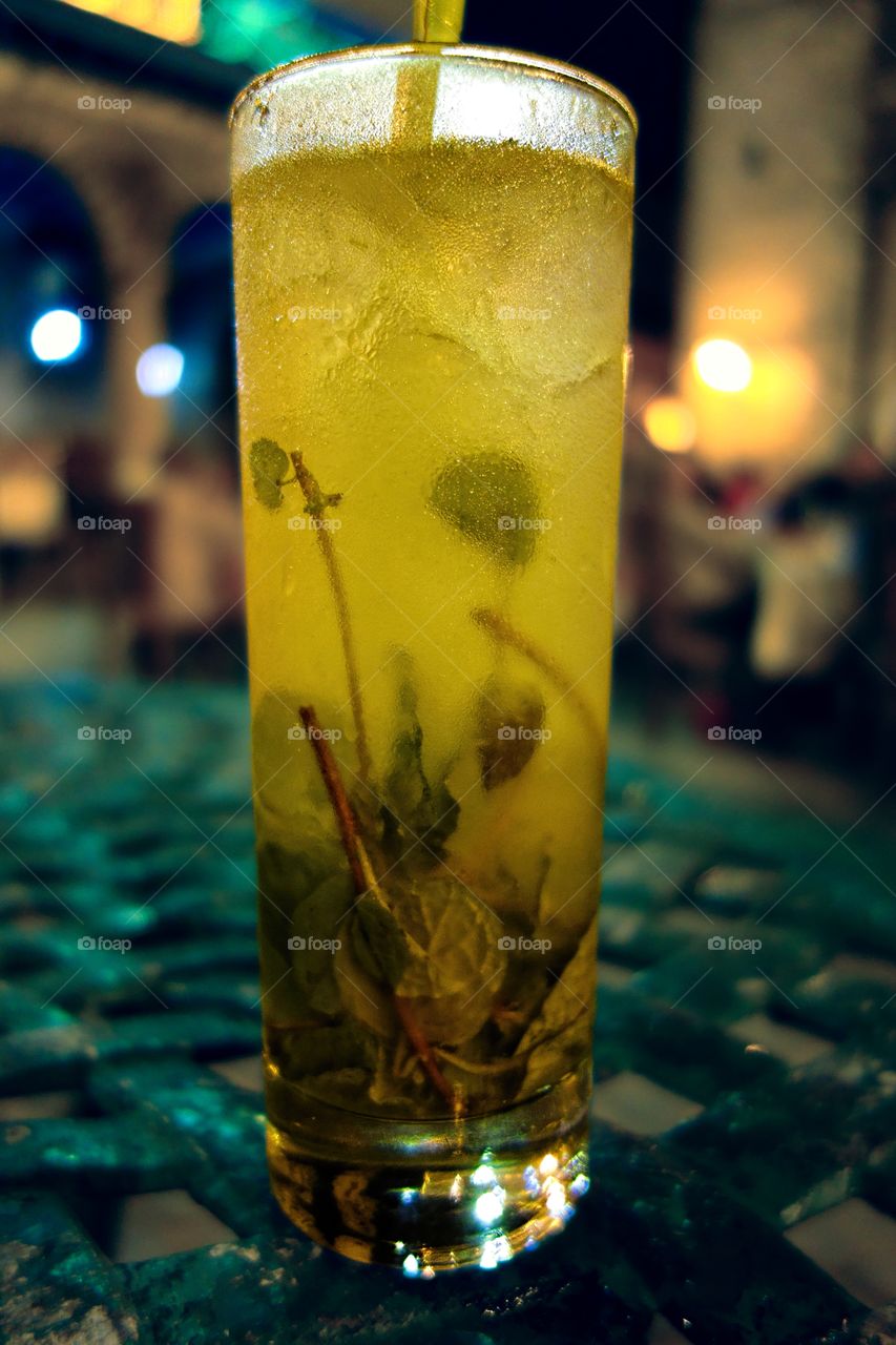 Traditional Cuban Mojito. Traditional Cuban Mojito served ice cold at an outdoors terrace in the old town of Havana, Cuba.