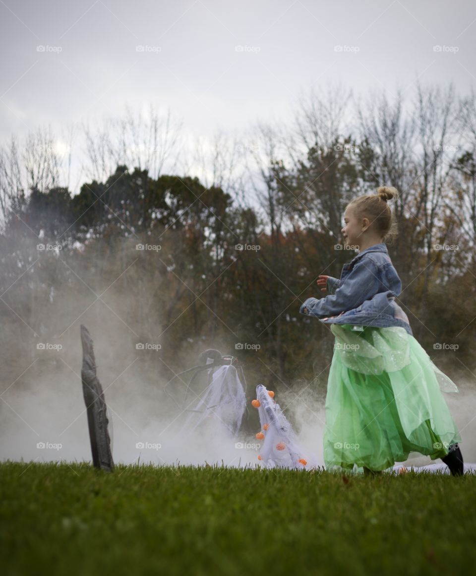 Princess running through a foggy, Halloween graveyard
