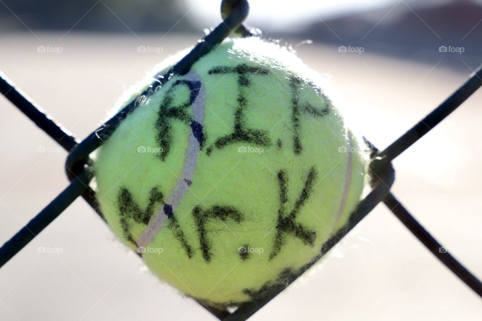 Tennis ball in fence as part of a memorial for a retired high school teacher and coach. Shot on Canon 6D Mark II