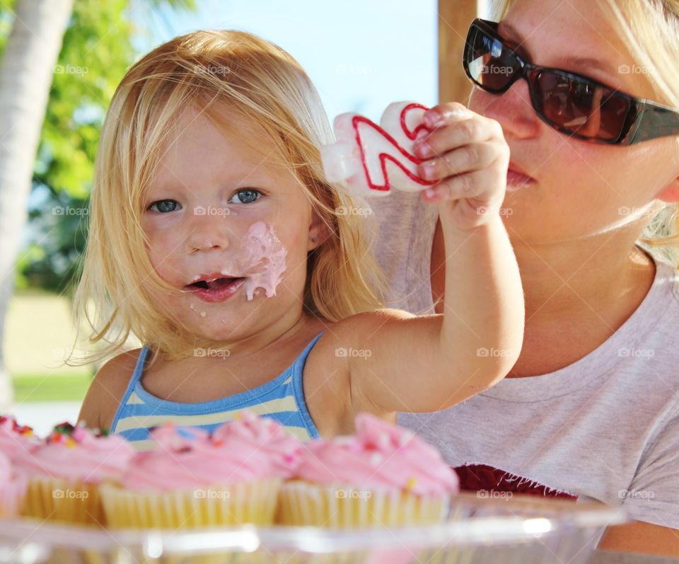 little girl eating cupcakes for her second birthday party