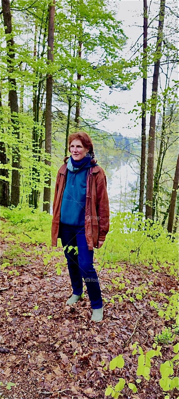This young lady doesn’t let a bit of rain get in the way of her enjoyment hiking in the „Bayerischer Wald“, the „Bavarian Forest“ by „Eging“ in Germany. 2024. Hypnotic Productions