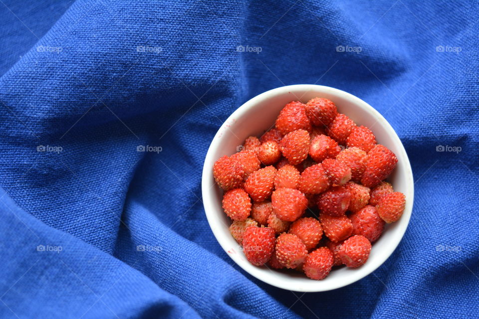 red strawberries on a plate tasty healthy summer food blue background