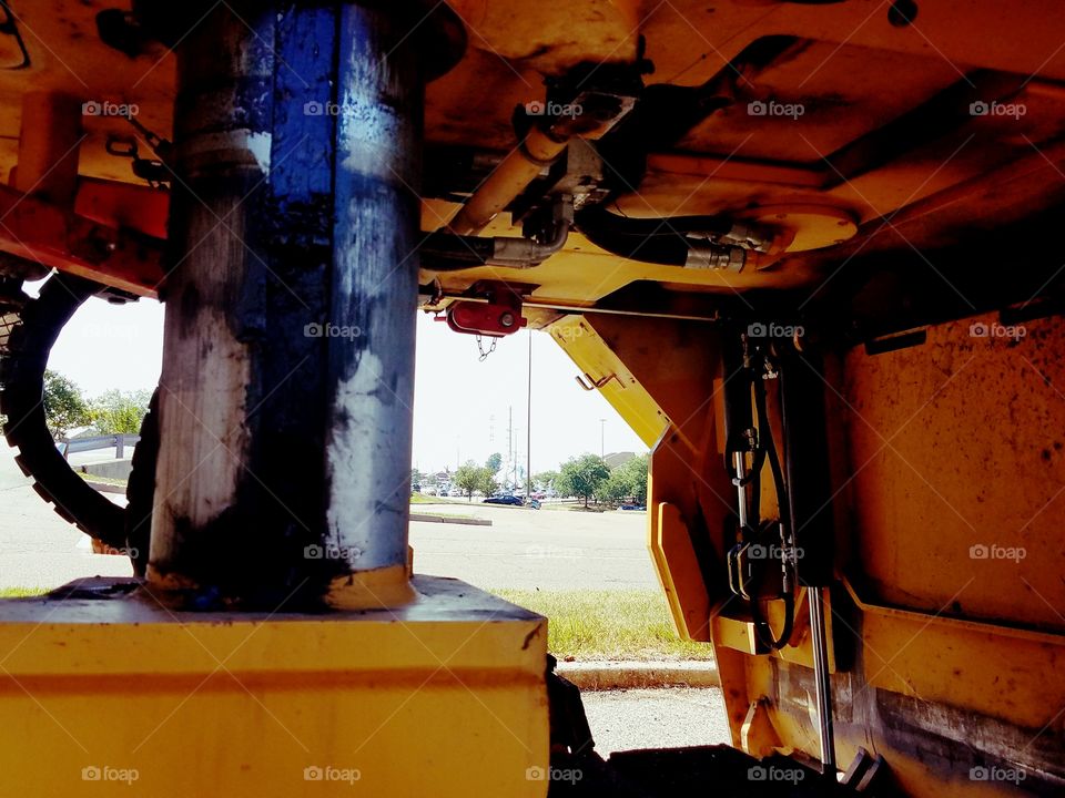 A closeup look at the under belly of a large construction machine.