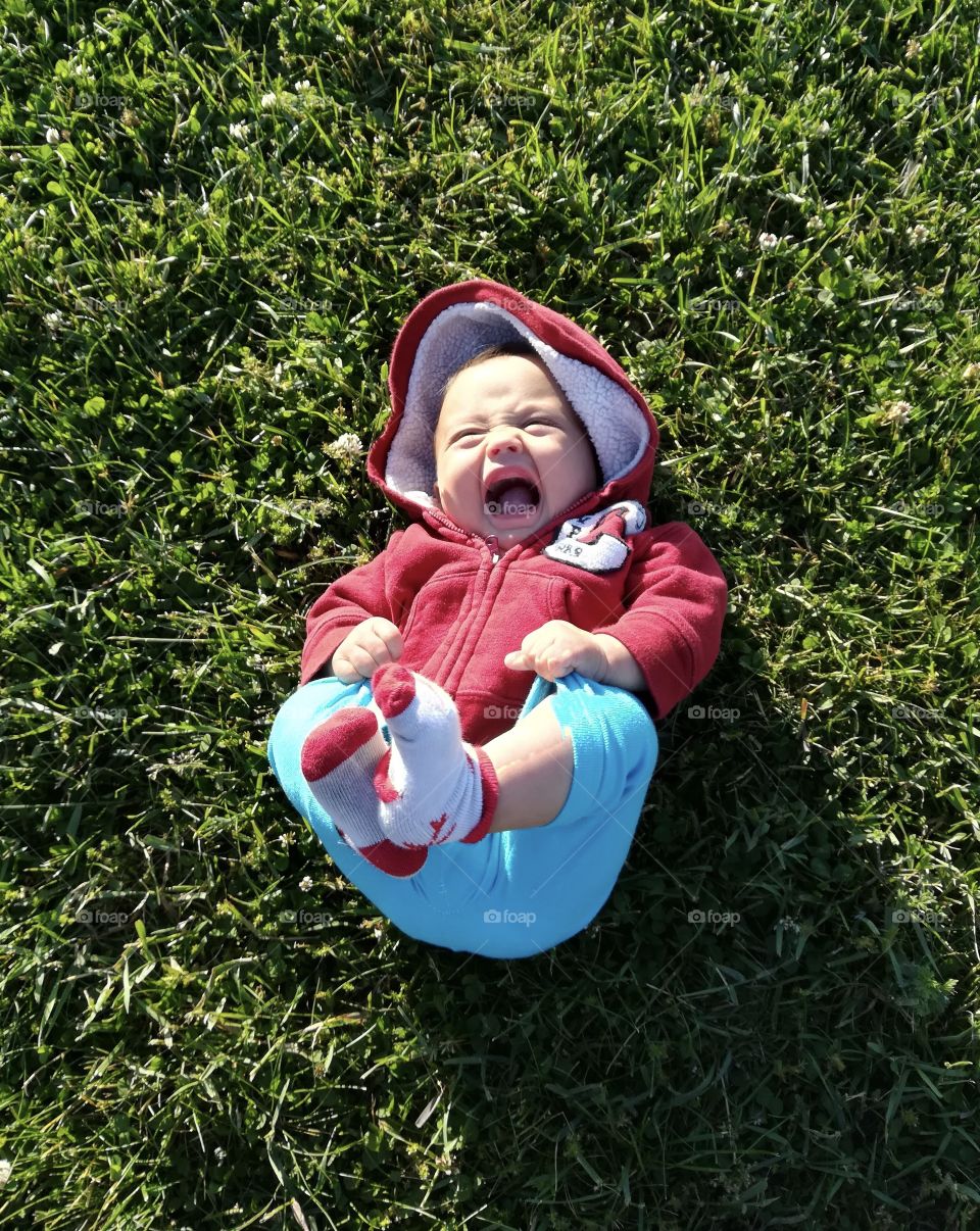 Baby boy laughing in the grass