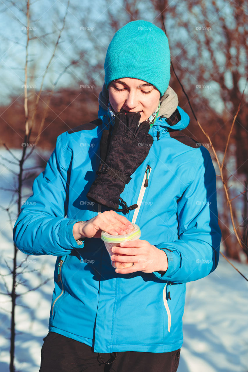 Boy opening box with snack during the journey in the wintertime