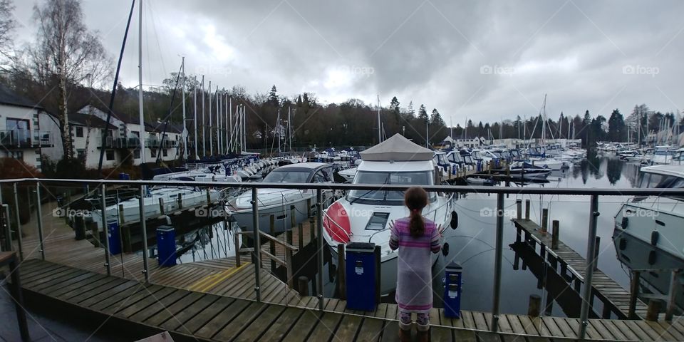girl looking at boats in harbour