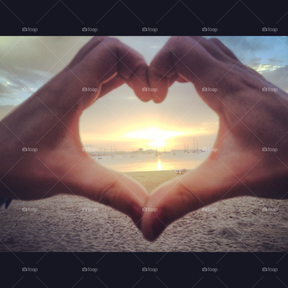 Close-up of  hands holding heart shape against sky