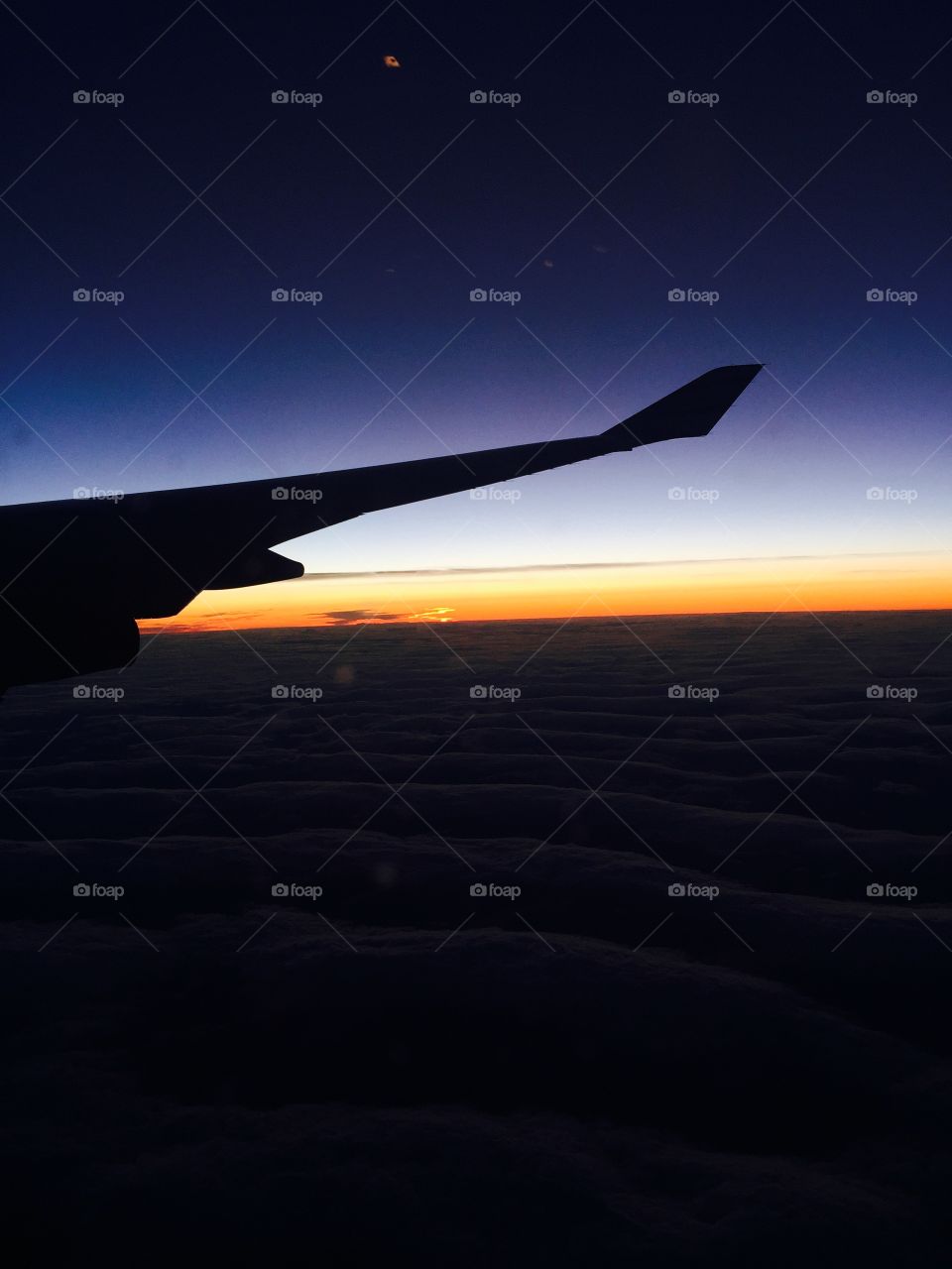 Silhouette of aircraft wing against sky