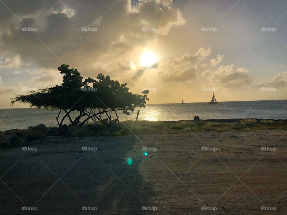 Sunset over the beach, sailboat and trees in Aruba during our UTV excursion with Carnival Sunshine Cruise 2018