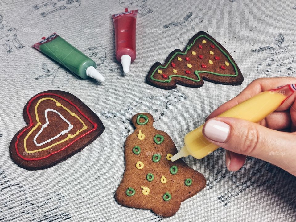 Person decorating gingerbread cookie