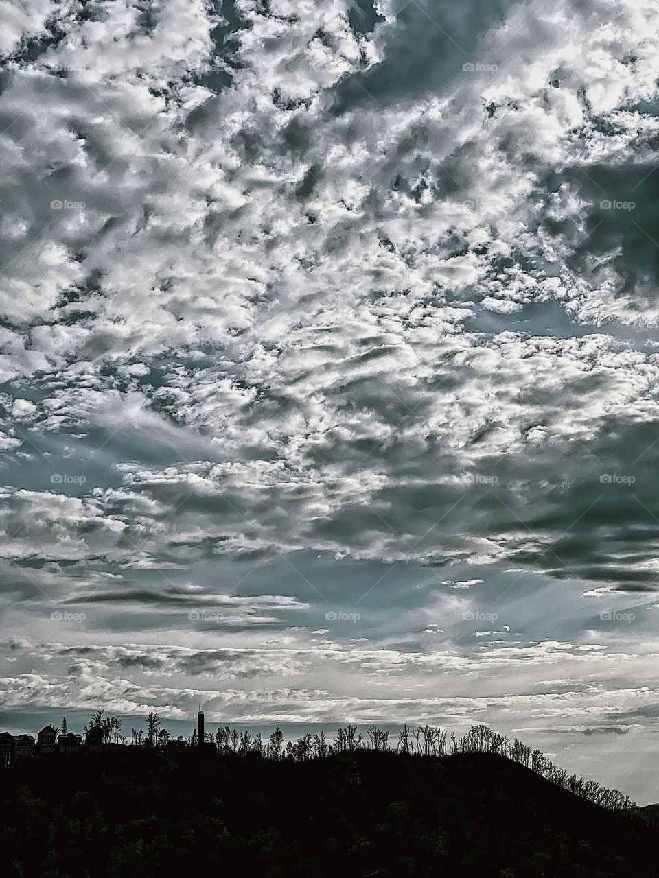 Clouds and sky in Tennessee, the big sky near Dollywood, shadow of the forest against a bright sky with clouds, outlines of nature, blue skies and tree lines, wilderness in Tennessee 