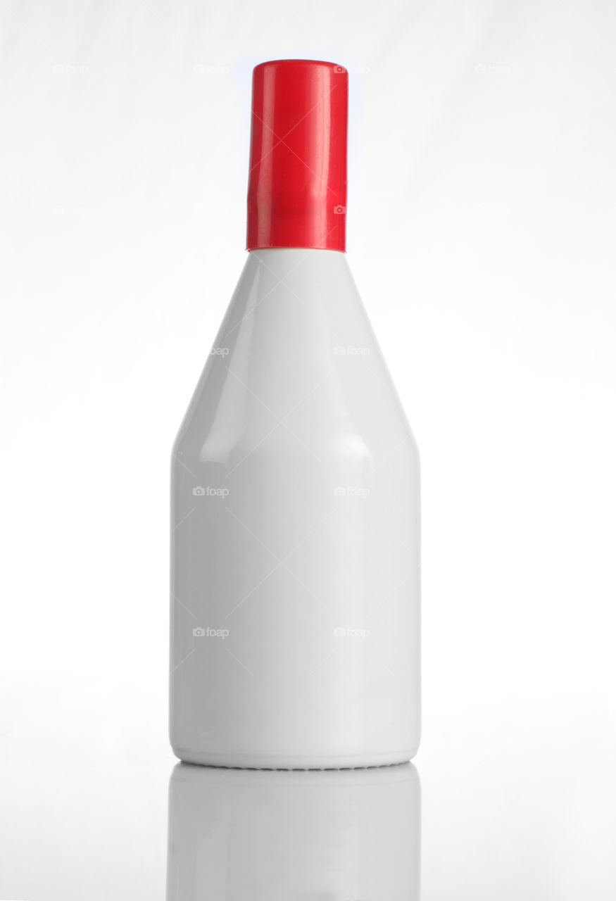 White perfume bottle with red cap isolated on white background