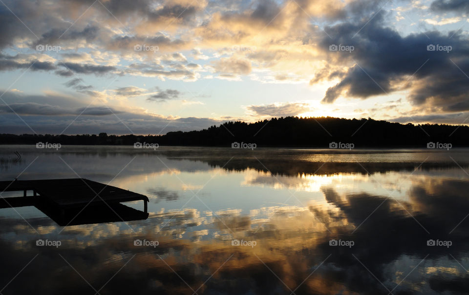 sunrise time on the lake - forest and pier silhouettes