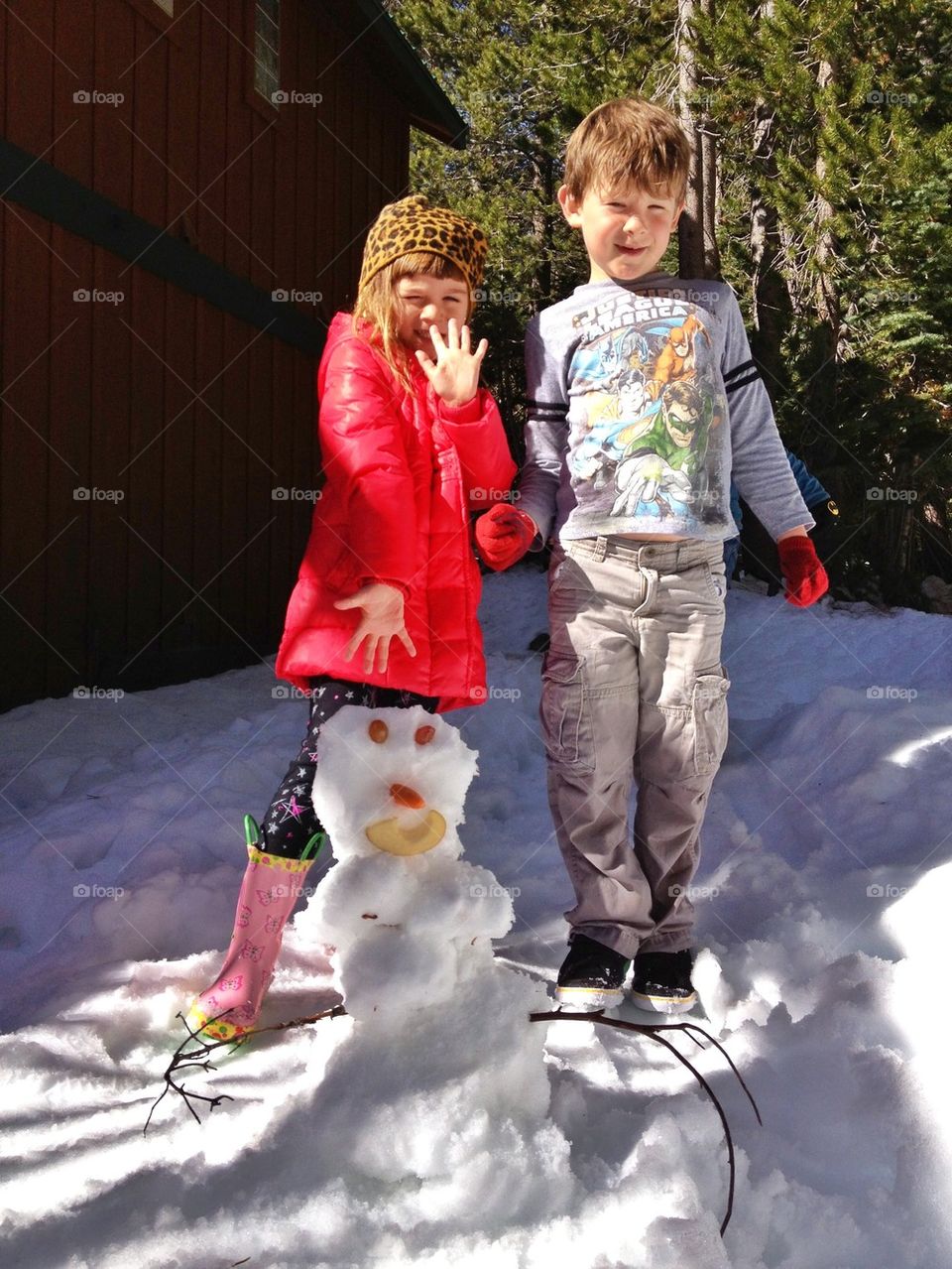 Boy And Girl Showing Off Their Snowman
